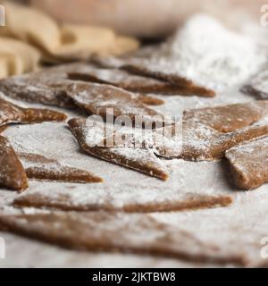 preparing of mung bean sweets to be fried, also known as mung kavum, diamond-shaped traditional sweets in sri lanka made with mung beans , rice flour Stock Photo