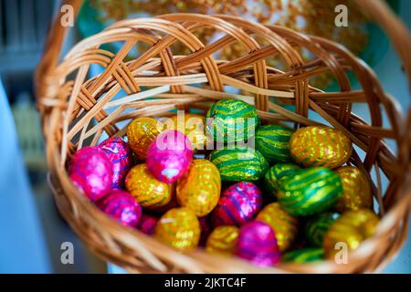 A closeup of a pile of chocolate Easter eggs in a basket. Stock Photo