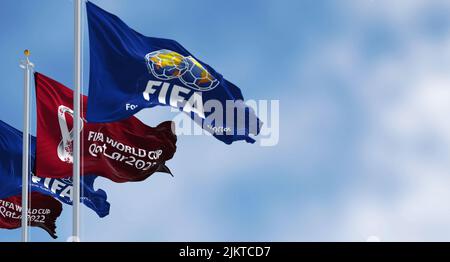 Doha, Qatar, January 2022: Flags with FIFA and Qatar 2022 World Cup logo waving in the wind. The event is scheduled in Qatar from 21 November to 18 De Stock Photo