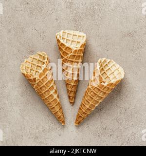 A close-up shot of three empty ice cream cones over brown background Stock Photo