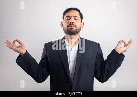 indian businessman with gyan mudra meditation yoga posture in white background Stock Photo