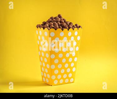 A close-up shot of delicious cereal on popcorn on a yellow background Stock Photo