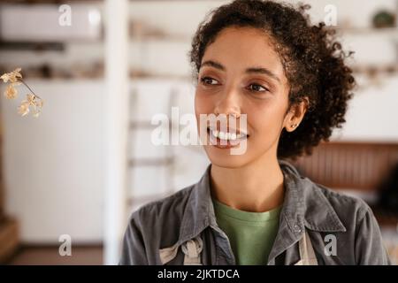 Young black woman wearing shirt smiling while standing indoors Stock Photo