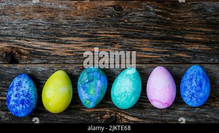 Painted and colored Easter eggs on rustic wooden table Stock Photo