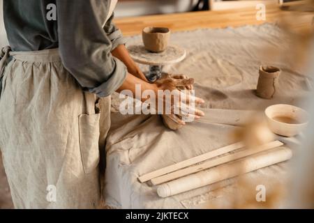 Young black ceramist woman wearing apron sculpting in clay at her workshop Stock Photo