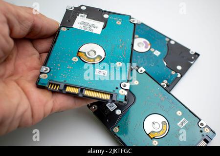 Stack of internal laptop hard drives in a pile hand holds up Stock Photo
