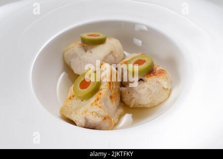 Chicken meat with green olives in a white plate Stock Photo