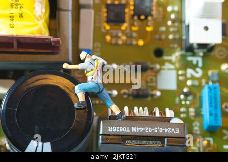 closeup of a climber with equipment climbs an electronic circuit board Stock Photo