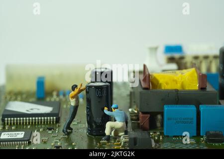two workers inspect components on an electronic circuit board Stock Photo