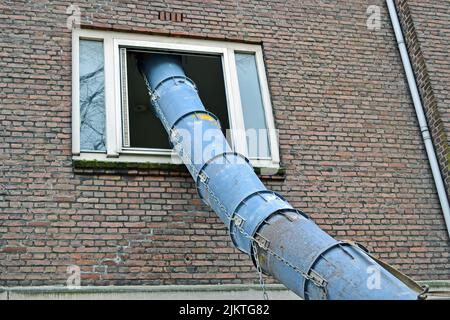 big industrial pipe into window hole, modern construction diversity Stock Photo