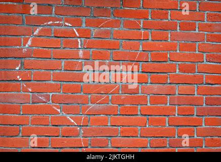 heart sign drawn by white chalk on red brick wall, love diversity Stock Photo