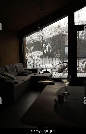 A vertical shot of the interior of a cozy house with a forest in the background Stock Photo