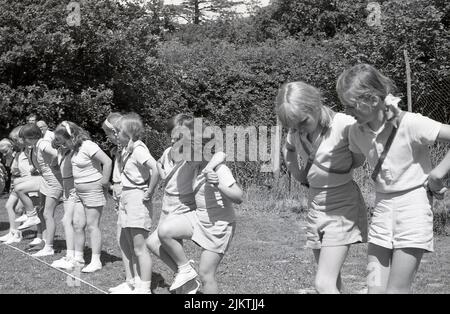 1966, historical, school sports, outside in a field, young girls in gym clothes lined up for the start of the three-legged race, England, UK. Stock Photo