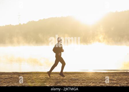 silhouette of a man, running outside in the morning. Stock Photo