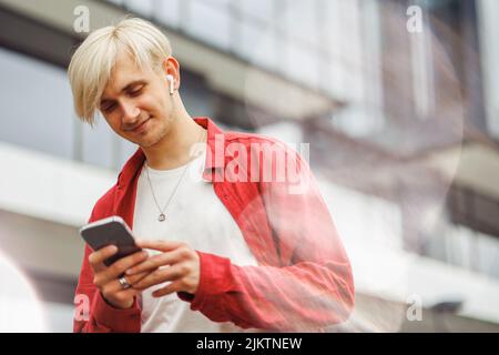 Man with phone in hands. Technology business. Freelancer doing his work on the way. Stock Photo