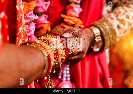 A closeup of hands with henna tattoos during an Indian traditional wedding ceremony Stock Photo