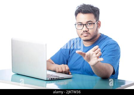 man using laptop and showing empty hand towards front Stock Photo