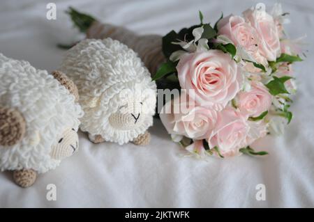 A simple wedding bouquet with two soft sheep on the bed Stock Photo