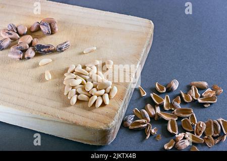 Pine nuts on a wooden kitchen board ready to taste. Stock Photo