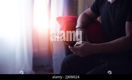 handsome man at home using his cell phone Stock Photo