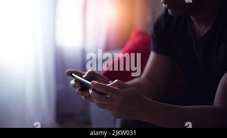 handsome man at home using his cell phone Stock Photo