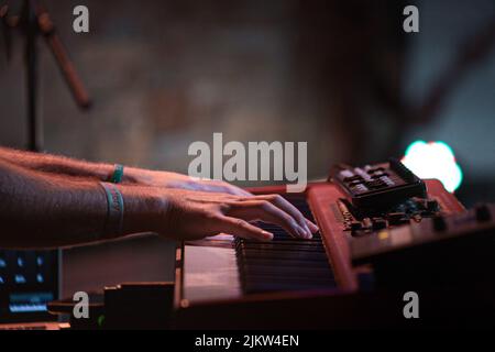 A selective focus shot of a man playing on synthesizer Stock Photo