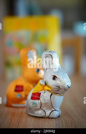 The Favorina brand Easter chocolate bunny packed in silver foil standing on a wooden table Stock Photo