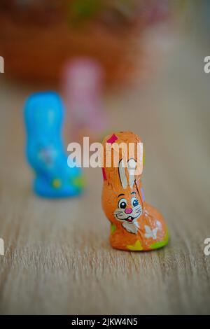 The Favorina brand small Easter chocolate bunny packed in brown foil standing on a wooden table Stock Photo