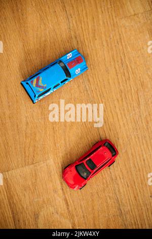 The blue and red Mattel Hot Wheels toy model cars on a wooden floor Stock Photo