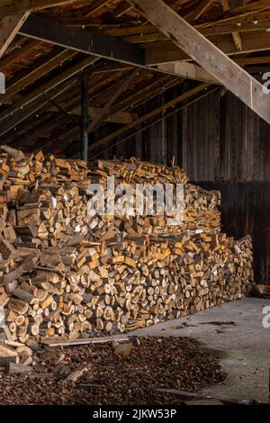 A vertical shot of a lot of firewood in a barn Stock Photo