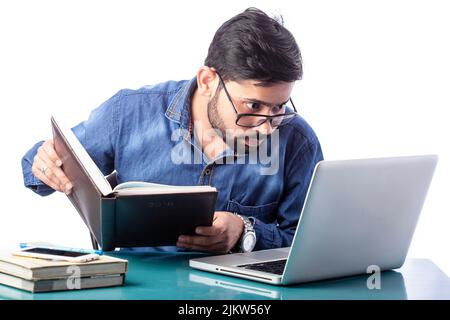single person looking at laptop screen holding diary on hand in isolated background Stock Photo