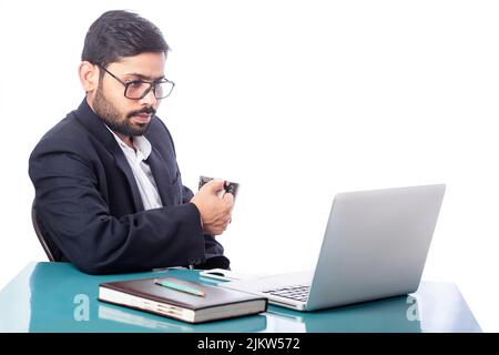 businessman drinking coffee and looking at laptop screen in isolated background Stock Photo