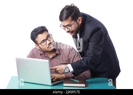 indian boss screaming or shrieking on employee while angry employee looking towards manager Stock Photo