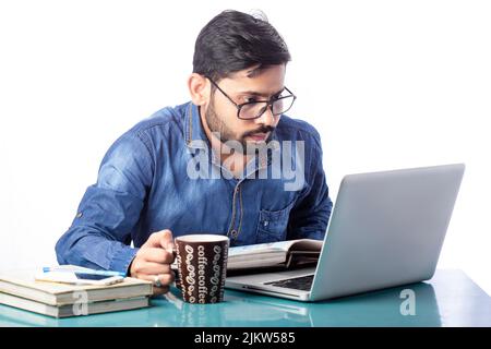 man working on laptop while drinking coffee in cold morning time. Stock Photo