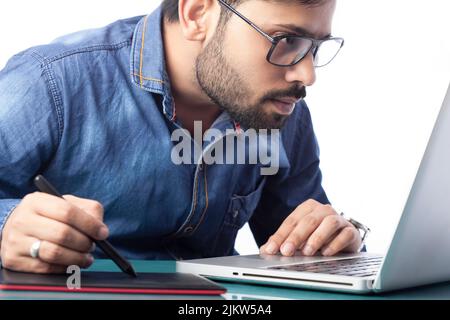 young digital artist using stylus pen and digital tablet for drawing and editing Stock Photo