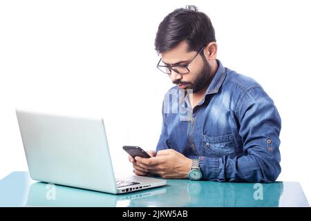 young business man typing on cell phone while working on laptop Stock Photo