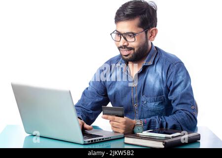 man smiling and shopping online and making online payment on laptop Stock Photo