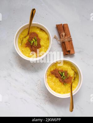 Two portions of saffron rice pudding served with cinnamon. Stock Photo