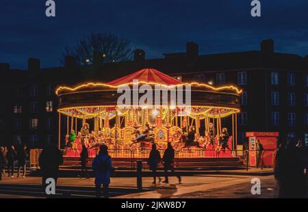 A rotating carousel with horses in playground of London at night Stock Photo