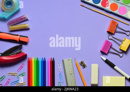 A top view of  lilac background, various school supplies, the concept of education and training. Stock Photo