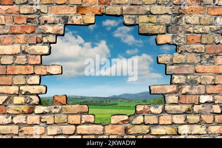 Hole in brick wall with a view of the outside Stock Photo