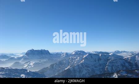 Morning fog between snowcovered mountain tops in Fieberbrunn, Austria. Picture taken at 2500m altitude. Stock Photo