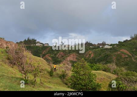 A rear view of a male hiker walking on mountain path Stock Photo