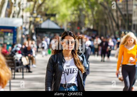 BARCELONA, SPAIN - APRIL 8, 2022: People walking along the Ramblas in Barcelona (Spain), the city's most famous street. Stock Photo