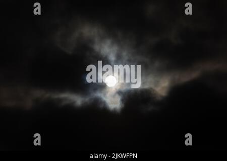 The Moon in a cloudy night sky Stock Photo