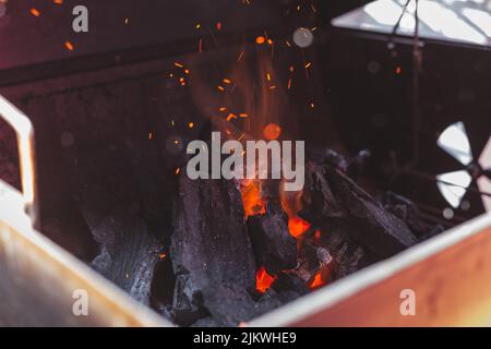 A closeup of the glowing campfire with charcoal and burnt wood. Stock Photo