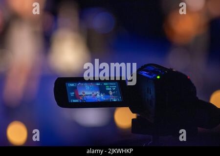 A selective focus shot of a recording video camera against a bokeh background Stock Photo