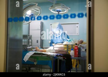 Orthopedic surgery operating room for knee prosthesis, the nurse makes the dressings. Stock Photo