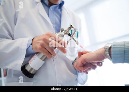 The dermatologist applies liquid nitrogen to reduce age spots. Stock Photo