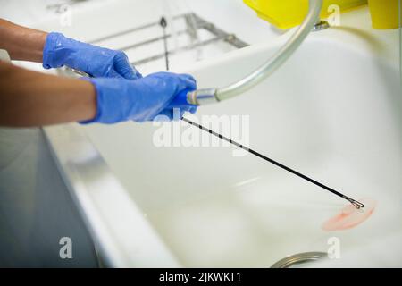 Before sterilization of surgical equipment, surgical instruments are washed by hand. Stock Photo